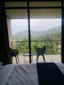 Mount view by farstay في واياناد: غرفة نوم بسرير وكرسيين وطاولة