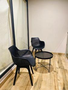 duas cadeiras e uma mesa em frente a uma janela em Mount view by farstay em Wayanad