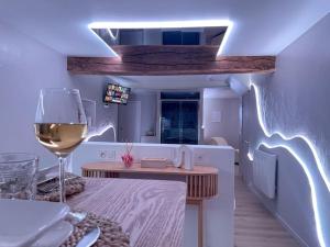 Cette chambre comprend une table et un verre de vin. dans l'établissement À la folie - Loft & Spa, à Montrevault