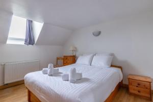 een slaapkamer met een wit bed en handdoeken bij La Nigaudière - Les Callunes in Lassay-sur-Croisne