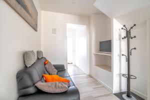 a living room with a leather couch and a television at Coeur de Ville 1 & 2 in Jonzac