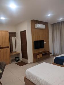 ein Hotelzimmer mit einem Bett und einem Flachbild-TV in der Unterkunft Mount view by farstay in Wayanad