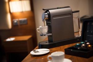 uma máquina de café com uma chávena sobre uma mesa em Thistle London Piccadilly em Londres