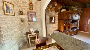 eine Küche mit einem Tisch und einer Steinmauer in der Unterkunft Juliet Suite by TrulyCyprus in Doros