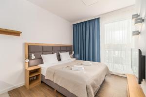 a bedroom with a bed and a large window at Perfect Holiday Apartments Bel Mare by Renters in Międzyzdroje