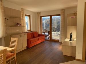 een keuken en een woonkamer met een bank en een tafel bij Obertrisaierhof Wohnung 2 in Fie allo Sciliar