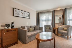 a living room with a couch and chairs and a table at Thistle London Piccadilly in London