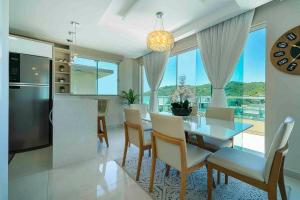 a kitchen and dining room with a table and chairs at Cobertura de Alto padrão in Bombinhas