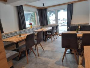 eine Reihe von Tischen in einem Restaurant mit Fenstern in der Unterkunft Zimmer & Appartements Schwarzenbacher Sonja & Konrad in Kleinarl