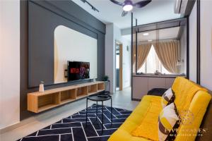 un soggiorno con divano giallo e grande specchio di The Luxe & Colony, KLCC a Kuala Lumpur