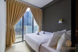 a bedroom with a bed and a large window at The Luxe & Colony, KLCC in Kuala Lumpur