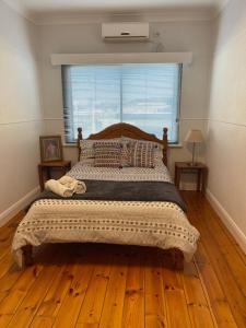um quarto com uma cama grande e piso em madeira em Apartment 1 on Oxide em Broken Hill