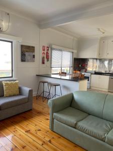 a living room with a couch and a kitchen at Apartment 1 on Oxide in Broken Hill