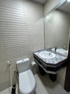 a bathroom with a sink and a toilet and a mirror at Homecation in Dubai