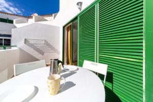 a white table and chairs with a cup on it at Soleado en Alondras Park in Costa Del Silencio