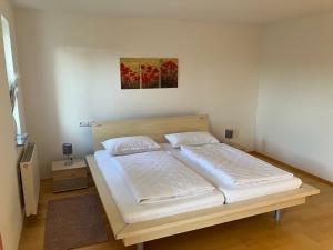 ein Schlafzimmer mit einem großen Bett mit weißer Bettwäsche in der Unterkunft Lorena in Dittelbrunn