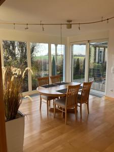 - une salle à manger avec une table, des chaises et des fenêtres dans l'établissement Lorena, à Dittelbrunn