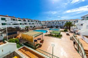 an apartment with a swimming pool and buildings at Soleado en Alondras Park in Costa Del Silencio