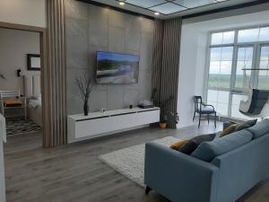 un salon avec un canapé et une table dans l'établissement Двухкомнатная квартира на самом берегу реки, à Pavlodar