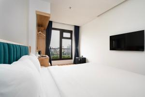 a hotel room with a bed and a tv at Haven Hut Riverside Hotel in Ho Chi Minh City +31 photos