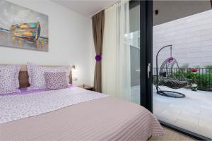 ein Schlafzimmer mit einem Bett mit lila Kissen und einem Balkon in der Unterkunft Lupo Gravosa FREE PARKING in Dubrovnik