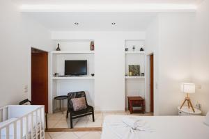 a bedroom with a bed and a tv and a chair at Jenny Apartments in Zakynthos Town