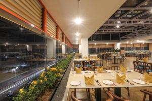 un restaurant avec des tables et des chaises dans une grande salle dans l'établissement IRA by Orchid Sambhajinagar - Aurangabad, à Aurangabad
