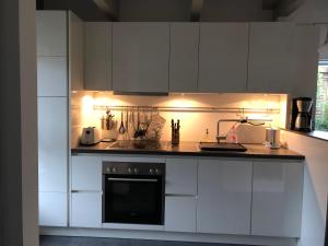 a kitchen with white cabinets and a stove top oven at Schlei 48 in Borgwedel