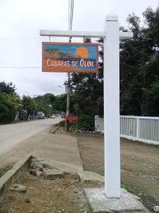 a sign on a pole on the side of a road at Cabañas Mar Olon in Olón