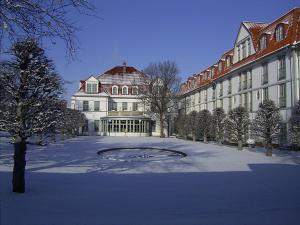 ハルバーシュタットにあるHotel Villa Heine Wellness & Spaの雪中の中庭がある大きな建物