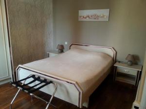a bed in a room with two tables and a chair at Le village in Polisy +5 photos
