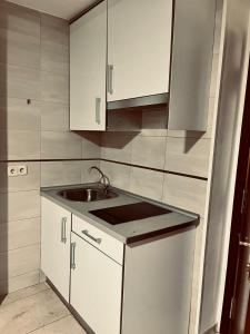 una cocina con armarios blancos y fregadero en APARTAMENTO 3p MENDIVIL MADRID CENTRO, en Madrid