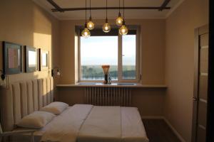 une chambre avec un lit avec des oreillers et une fenêtre dans l'établissement Двухкомнатная квартира на самом берегу реки, à Pavlodar