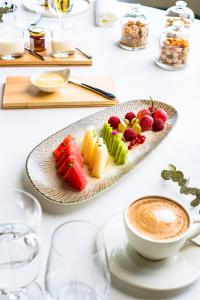 a table with a plate of fruit and a cup of coffee at Hotel Pico Velasco in Carasa