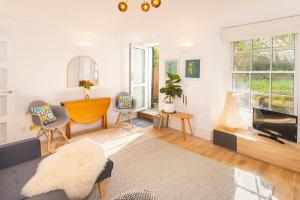 sala de estar con TV, mesa y sillas en Idyllic Clifton Hideaway - Stunning Garden Flat en Bristol