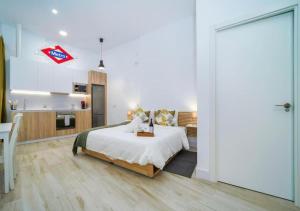 a white bedroom with a bed and a kitchen at (J6) Loft 4 personas Céntrico Madrid in Madrid