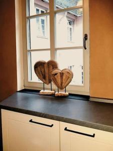 two wooden hearts sitting on a counter in front of a window at Komfortables Apartment im Zentrum Erfurts in Erfurt