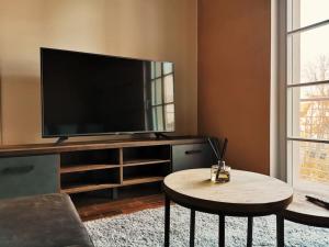 a living room with a flat screen tv and a table at Komfortables Apartment im Zentrum Erfurts in Erfurt