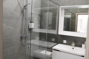 une salle de bain avec une douche en verre et un lavabo dans l'établissement Двухкомнатная квартира на самом берегу реки, à Pavlodar 12 autres photos
