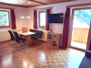 una camera con tavolo, sedie e televisore di Alpboden ad Auffach