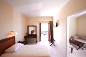 een slaapkamer met een bed, een spiegel en een bank bij Porto Delfino Retreat in Kapsálion