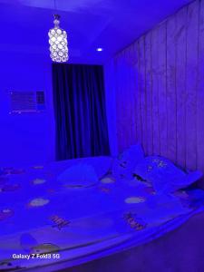 Schlafzimmer mit einem Bett mit blauer Beleuchtung in der Unterkunft O'ffidaus J Luxury Hotel And Suites Int Ltd in Benin City