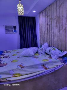 a bedroom with a large bed with a purple at O'ffidaus J Luxury Hotel And Suites Int Ltd in Benin City