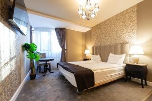 a hotel room with a large bed and a desk at Torres Poiana in Poiana Brasov