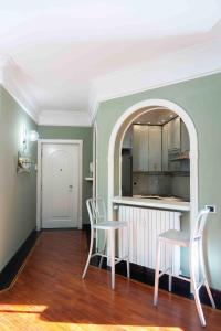 een keuken met 2 stoelen en een tafel in een kamer bij Penthouse Stefini 2 in Milaan