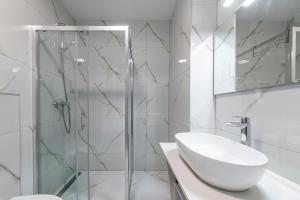 ein weißes Bad mit einer Dusche und einem Waschbecken in der Unterkunft Lupo Gravosa FREE PARKING in Dubrovnik