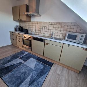 LitzendorfにあるFränkisch wohnen bei Melaのシンクと電子レンジ付きのキッチン