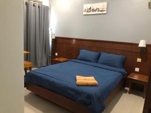 a bedroom with a blue bed with a wooden headboard at L23 ,88 Resort Villa House in Pangkor