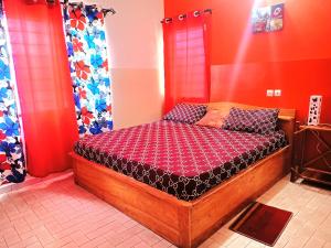 a bedroom with a wooden bed with red walls at Cloud9 Lomé in Lomé