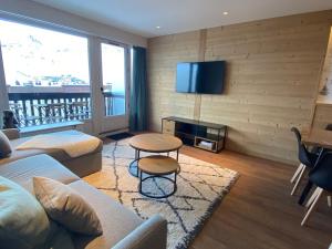 ein Wohnzimmer mit einem Sofa und einem TV in der Unterkunft Appartement Tignes, 3 pièces, 8 personnes - FR-1-641-32 in Tignes